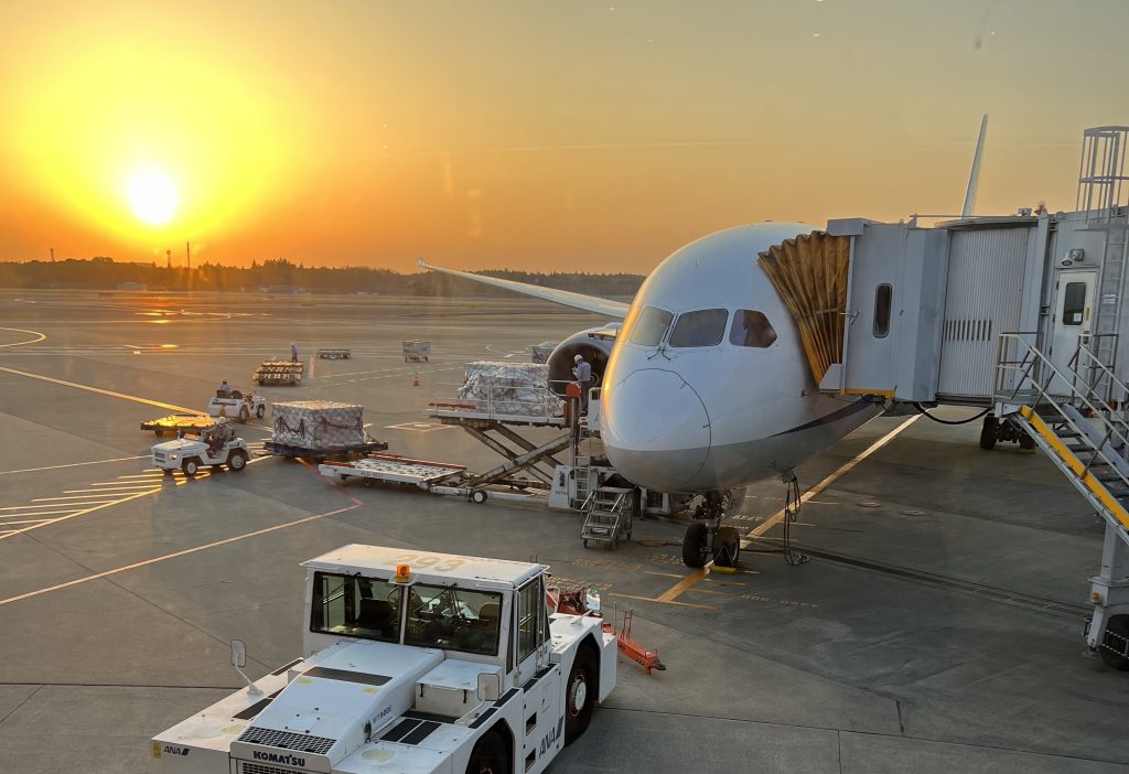 Airplane waiting to depart, sunsetting in the background.